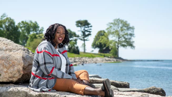 Lorna sitting on the rocks by the beach