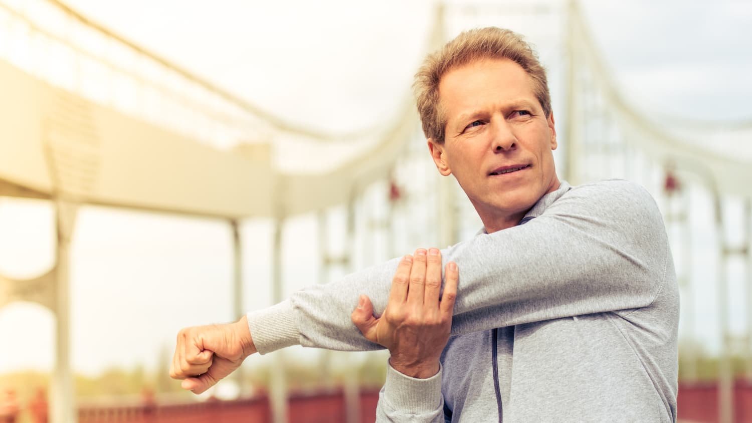 Man stretching before workout, possibly after receiving body-contouring surgery