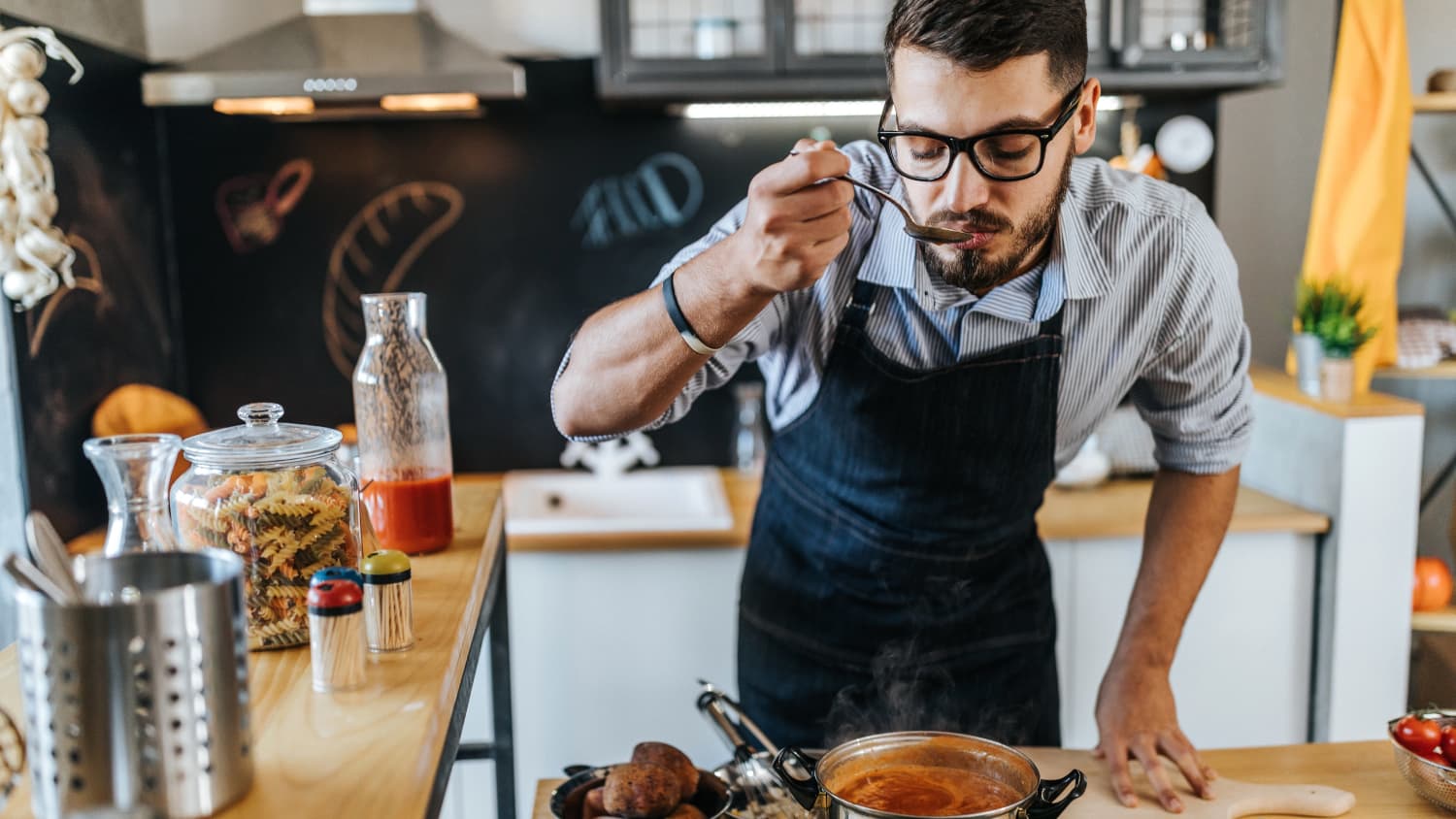 man cooking a meal, enjoying the renewed sense of taste and smell after recovering from COVID-19