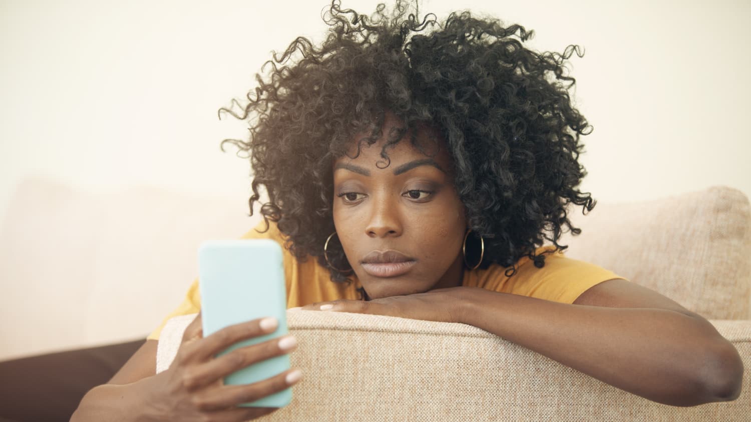 Woman looking at news updates on her phone, possibly to see connection between covid-19 vaccine and blood clots