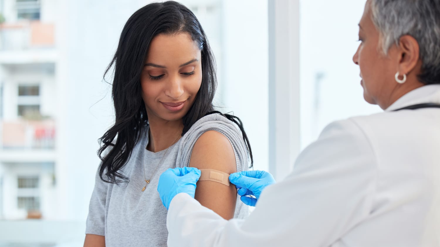 woman receiving updated 2024-2025 COVID vaccine