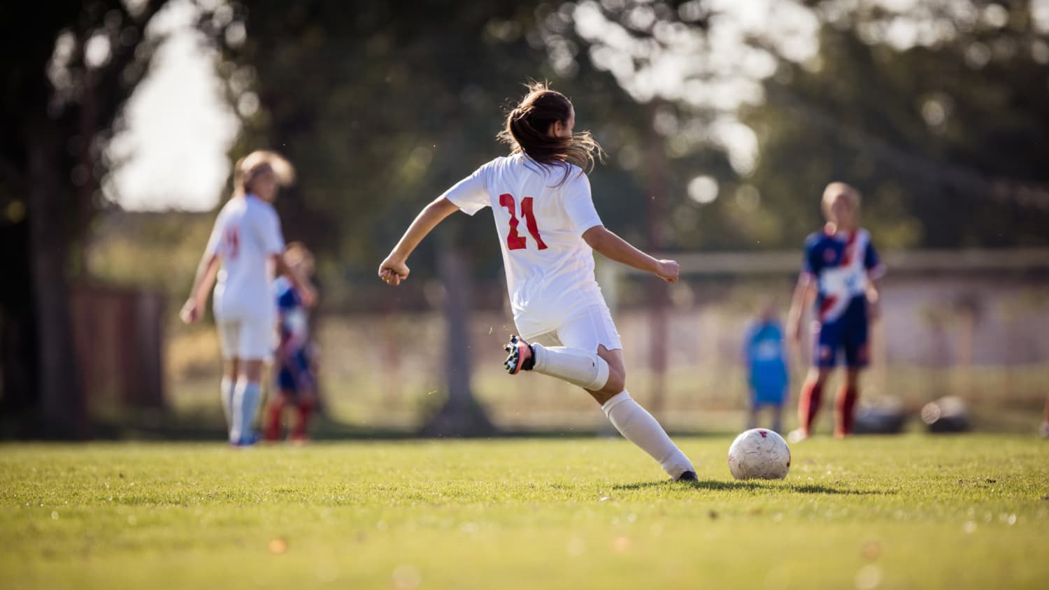 female soccer player kicking a soccer ball