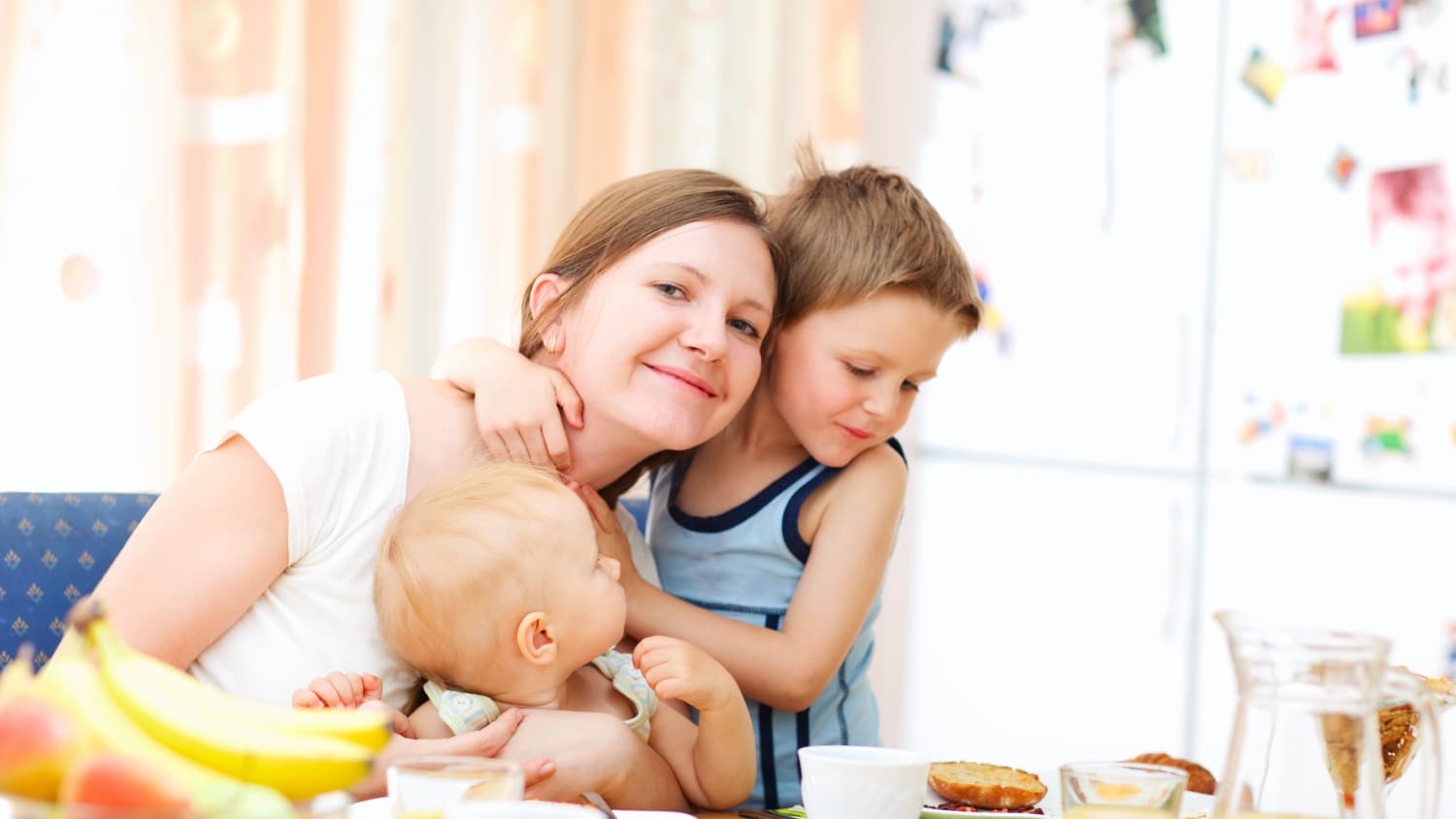 A mother with two young children at the breakfast table.