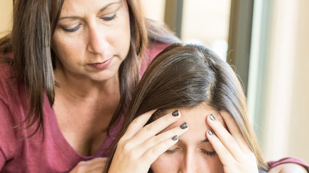 A woman comforts a teenage girl who is despondent over her parents' divorce.