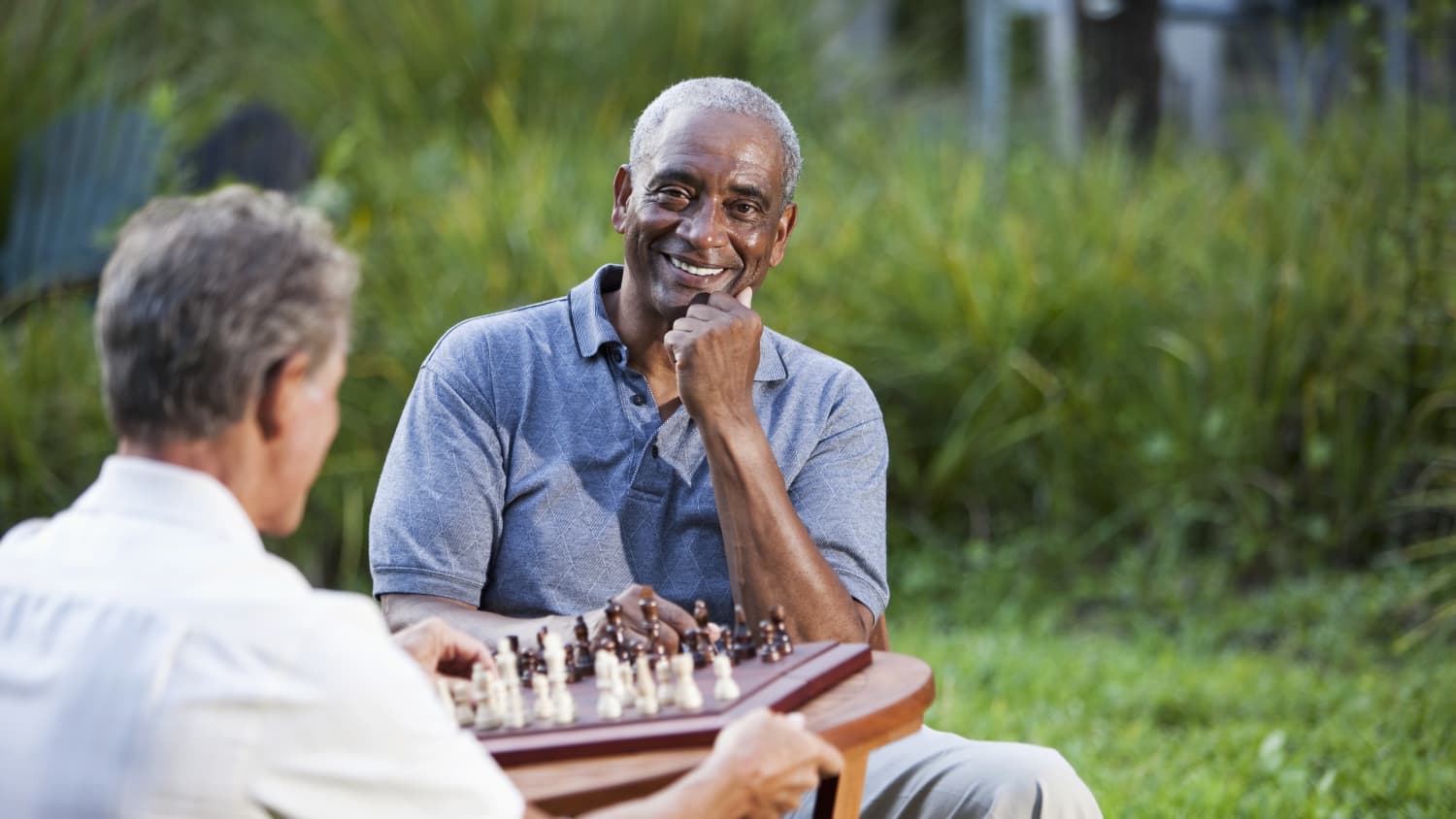 A senior African American man who may need a UroLift plays chess.