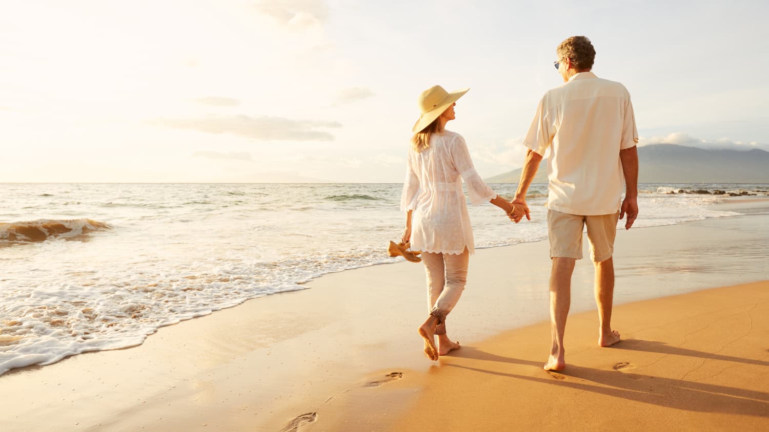 A couple strolls on the beach.after the man has had a vasectomy reversal.