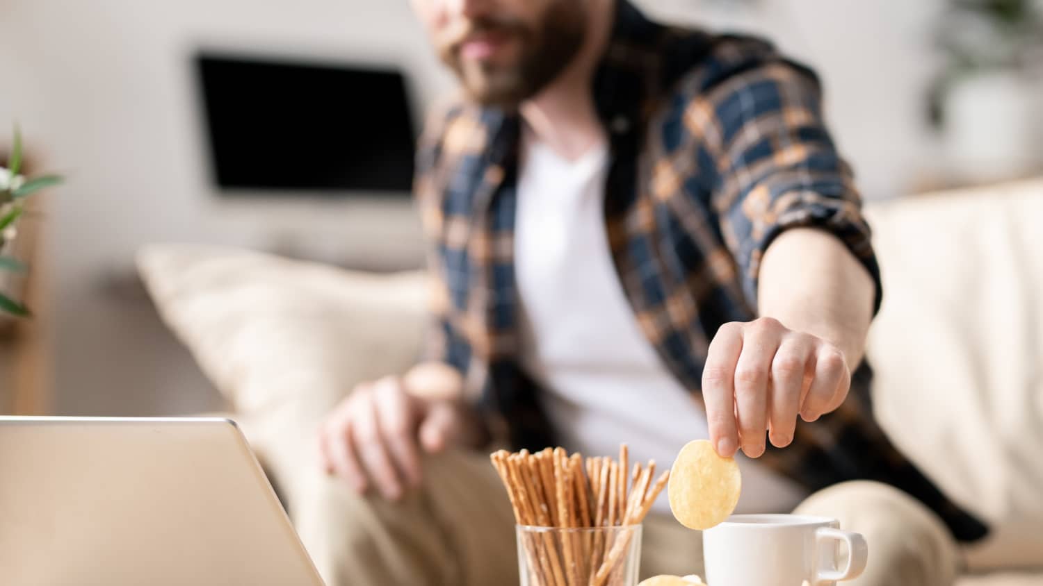 Man snacking, possibly in response to anxiety related to the COVID-19 pandemic