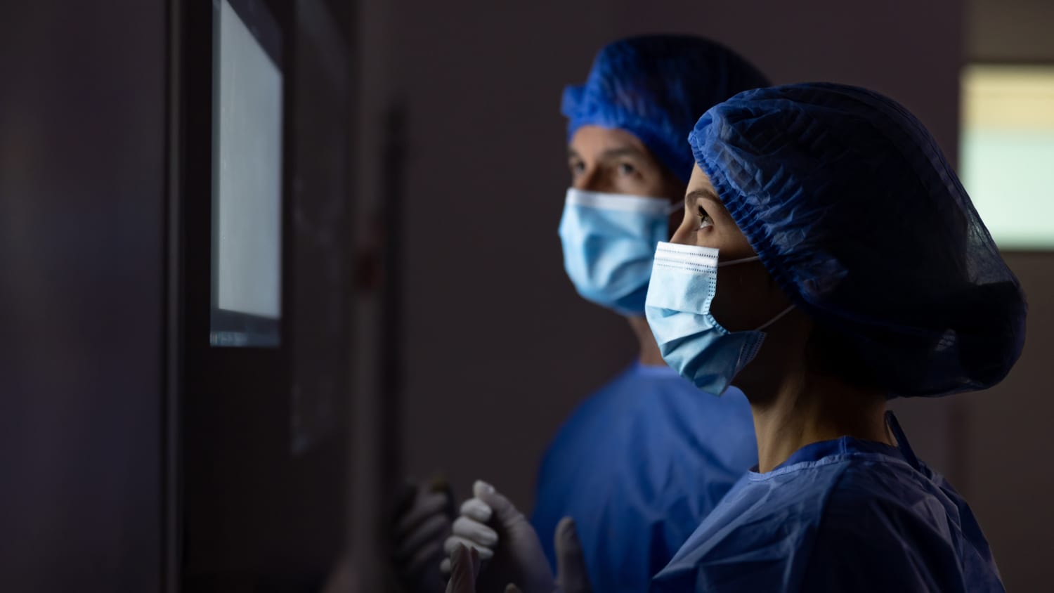 microsurgeons looking at a computer