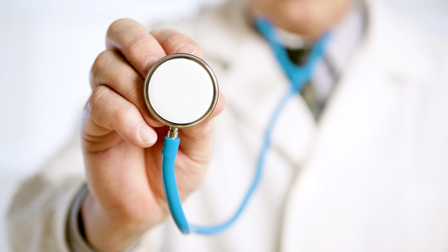 A doctor about to listen to the heart of a patient with coronary artery disease using a stethoscope.