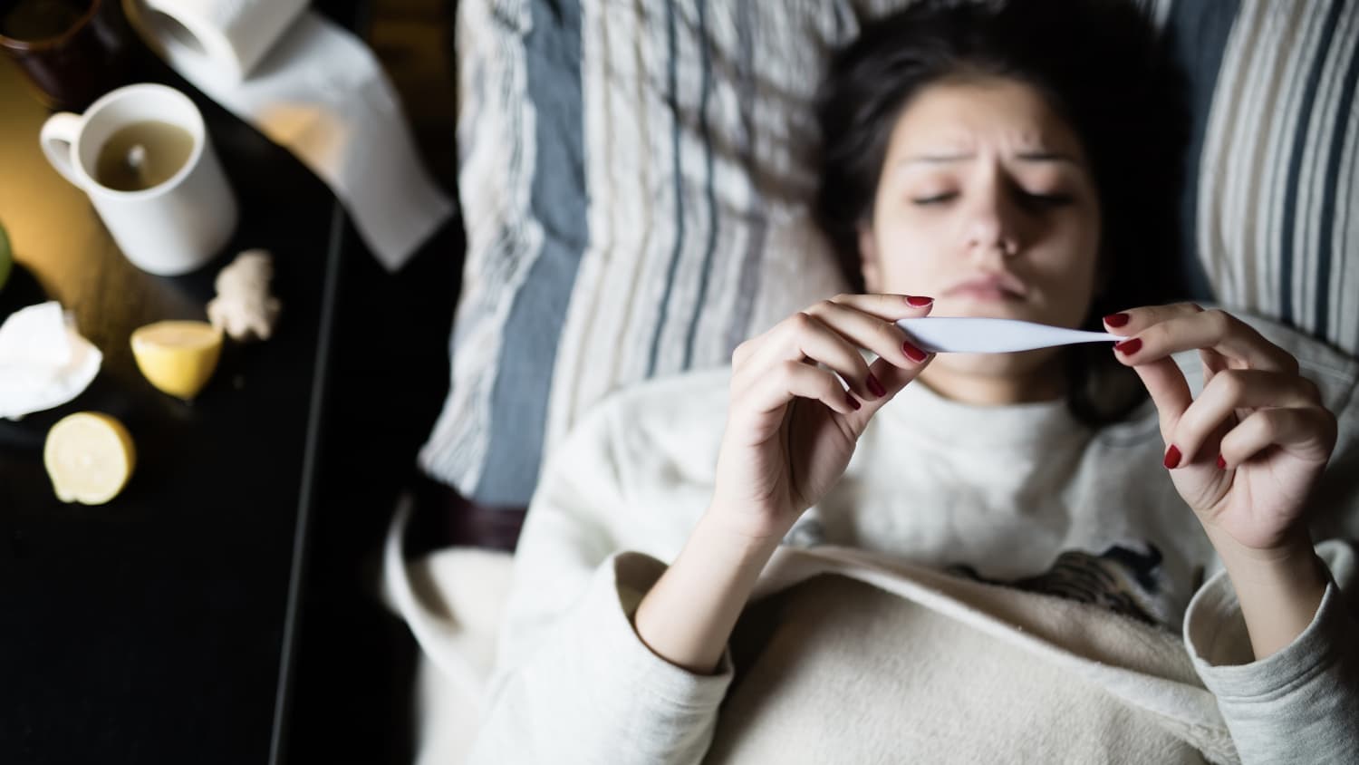 Sick woman laying in bed, possibly wth COVID-19