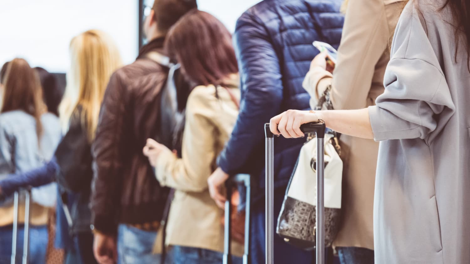 people standing in line at airport, worried about COVID-19 and Delta Plus