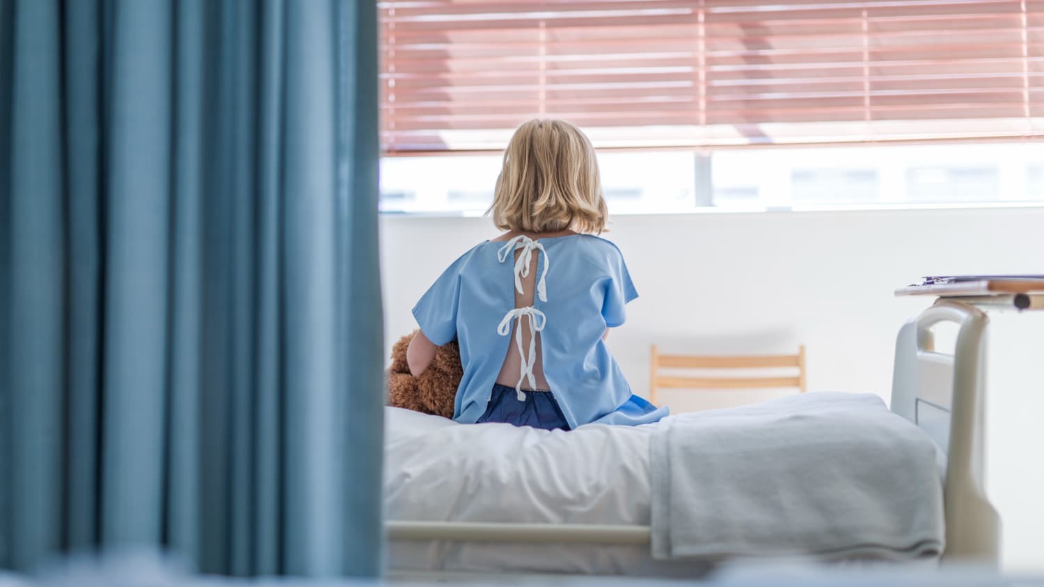 kid, possibly with hepatitis diagnosis, wearing a hospital gown on a hospital bed