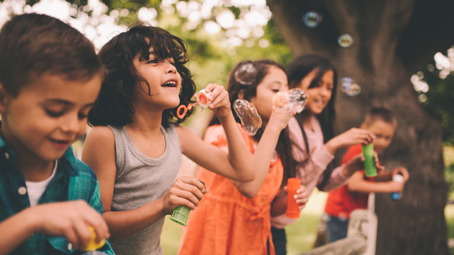 A child recovered from a brain tumor plays outside with friends.