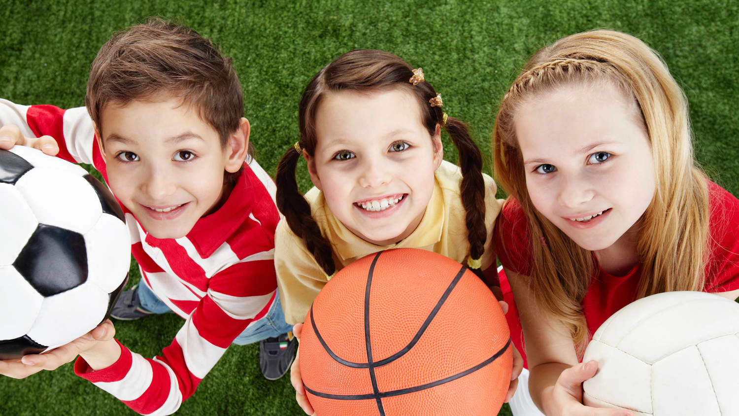 girls holding balls, smiling