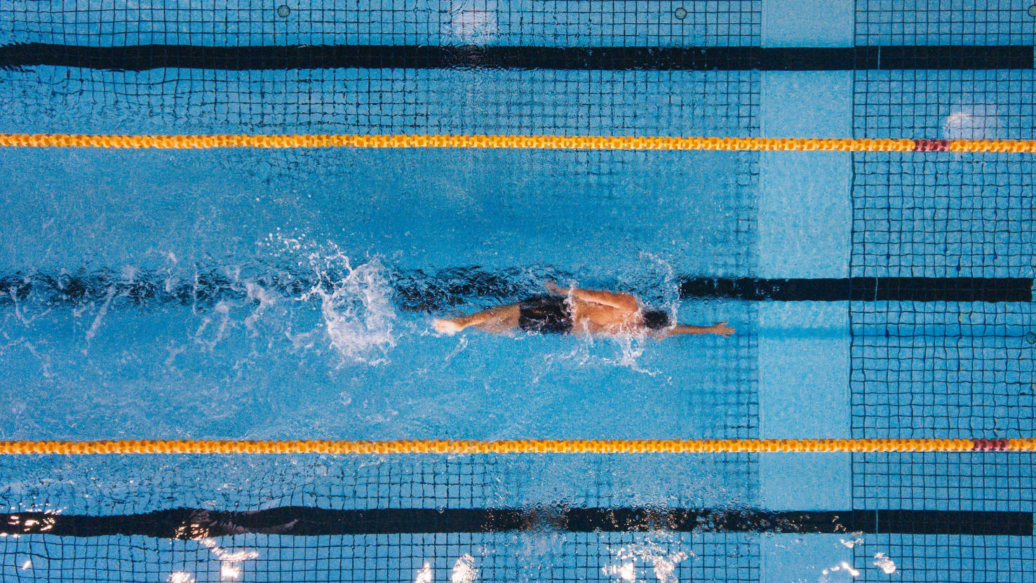 person swimming laps in a pool, showing good lung health