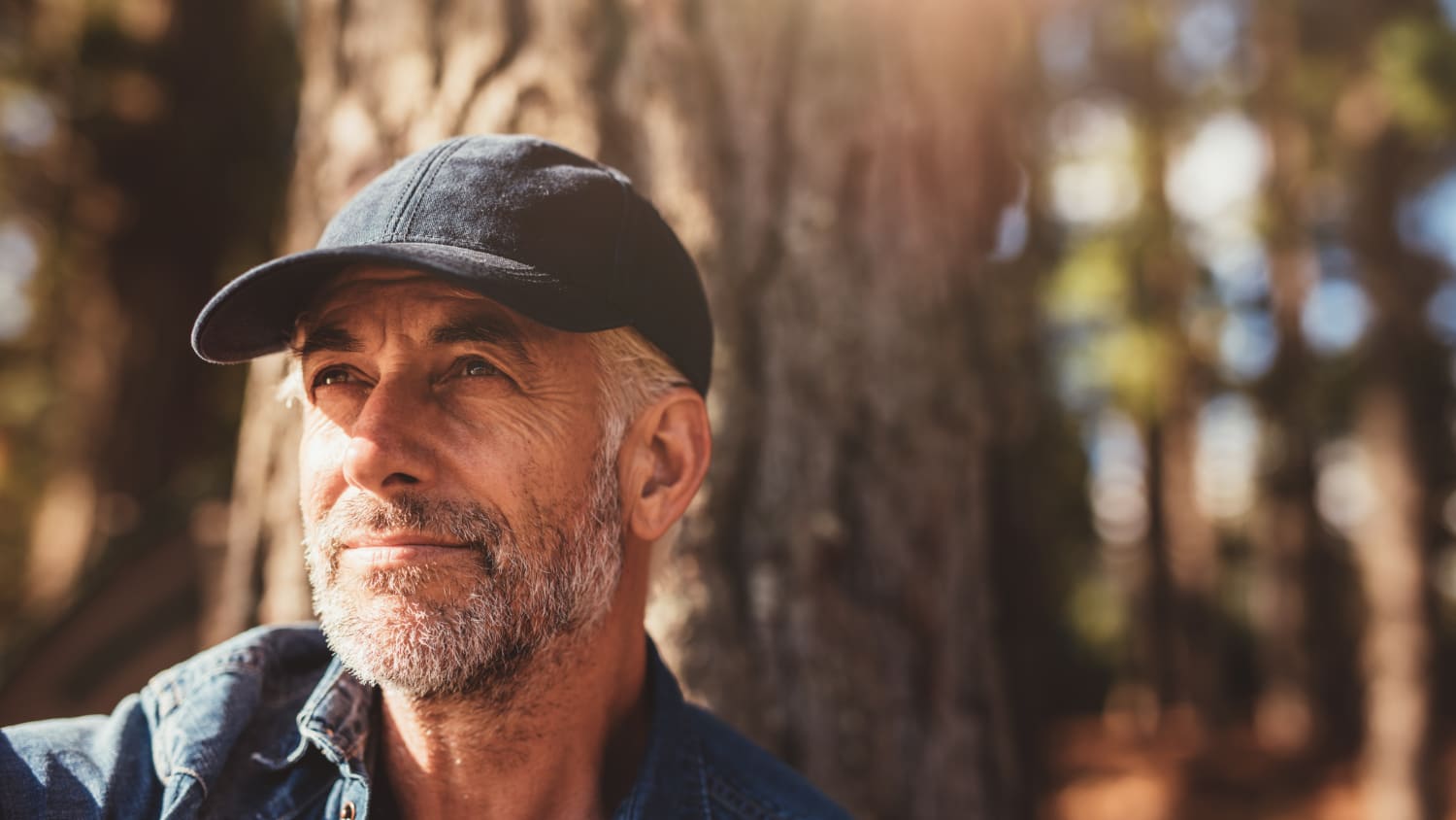 older man smiling in the woods after prostate cancer treatment