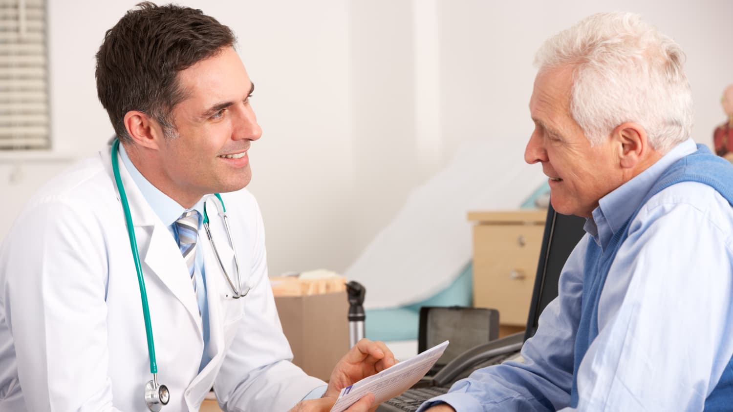 Male Doctor Speaks with Older Male Patient
