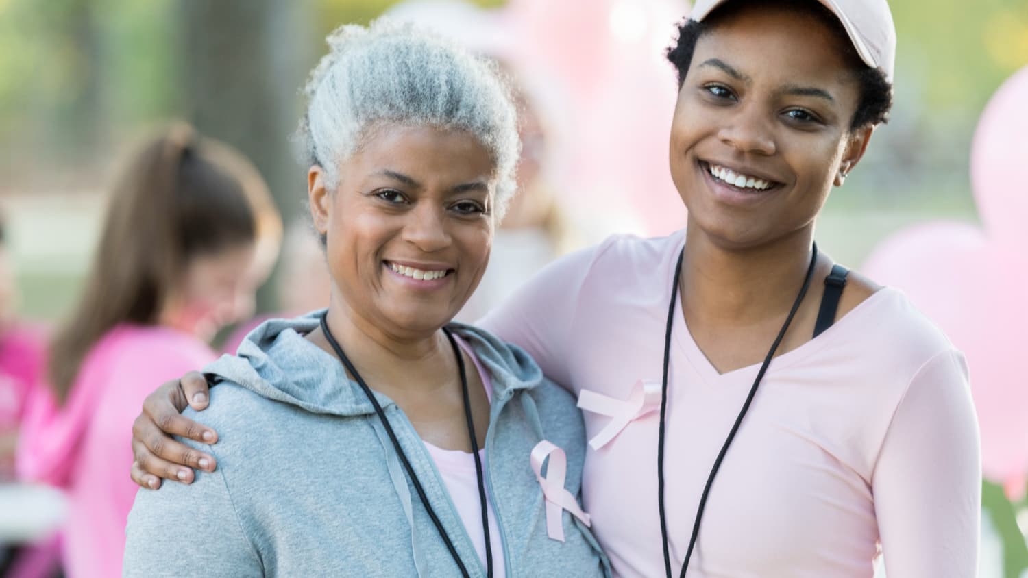 Senior woman and daughter smile for camera at race for breast cancer cure
