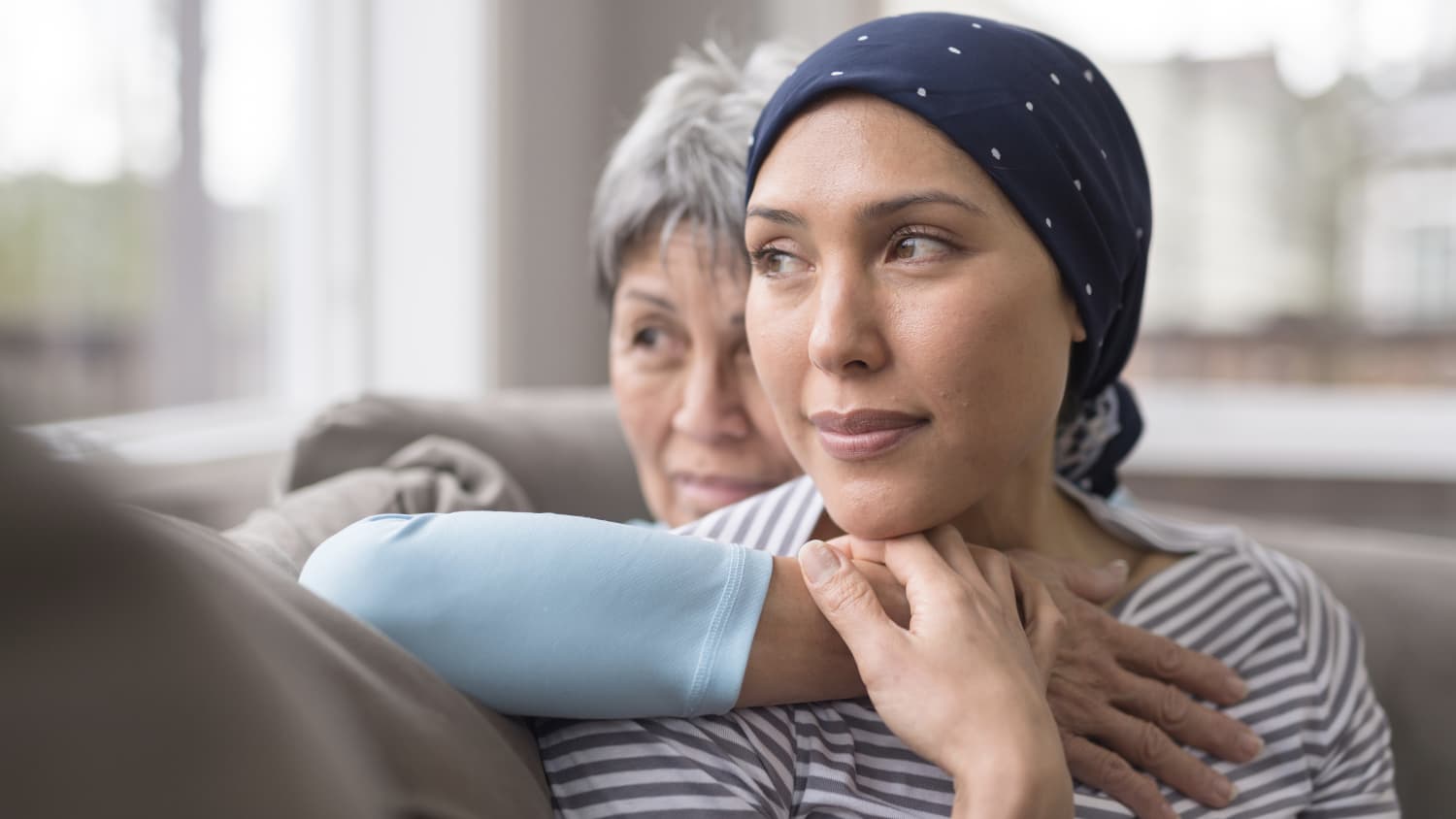 older woman holding younger woman, who has breast cancer