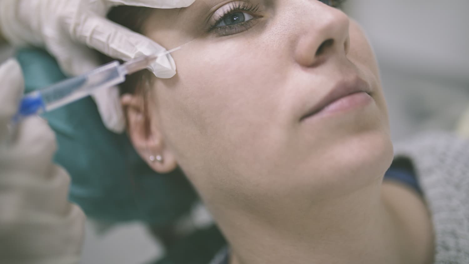  A woman receives botox treatment.