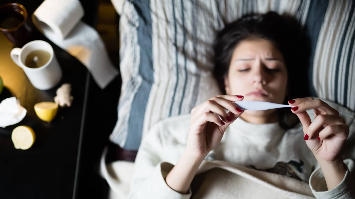 Sick woman laying in bed, possibly wth COVID-19