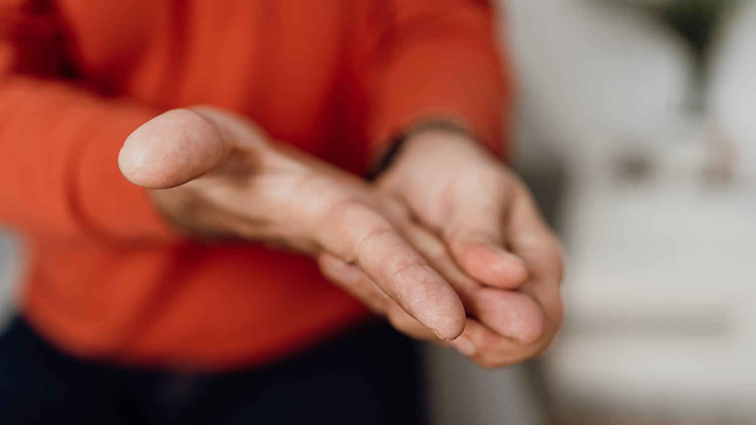 man massages his hand during a multiple sclerosis (MS) relapse