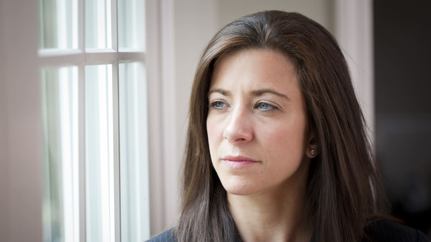 A woman with lupus gazes out the window.