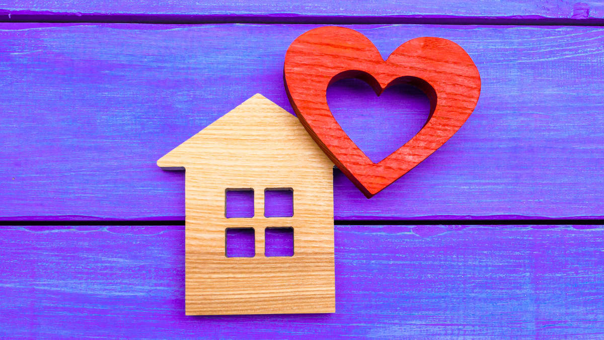 Wooden home cut-out with cut-out wooden heart, symbolizing Yale's home-based care programs