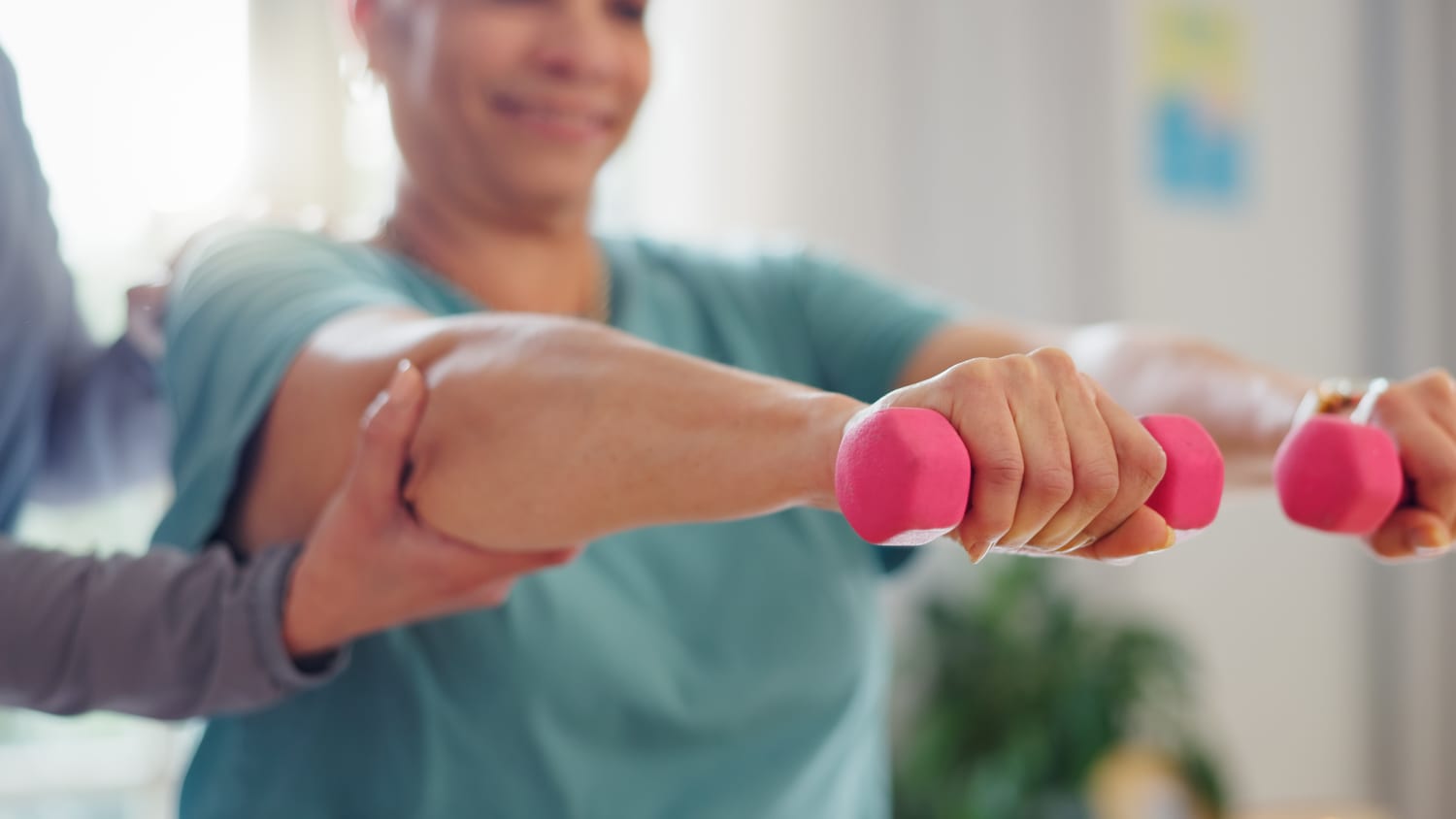 woman lifting small dumbbells