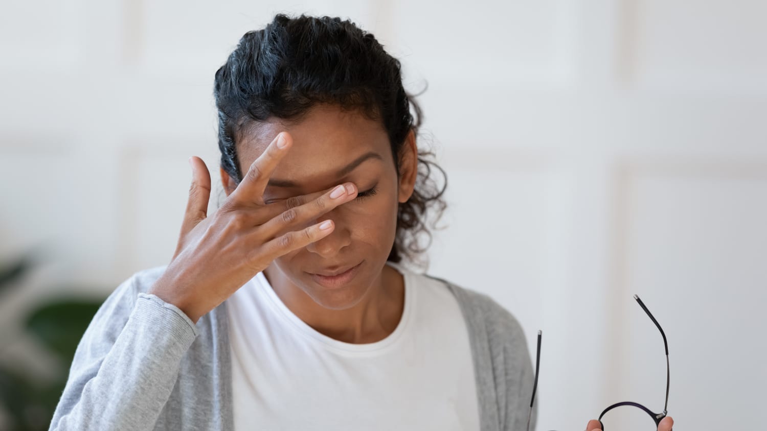 Woman with dry eye takes off her glasses and rubs her eyes to get relief.