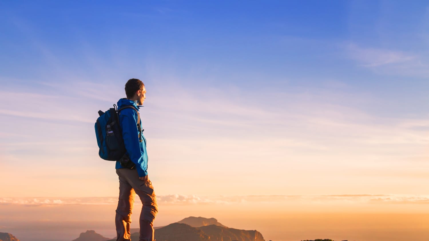 man on mountain top after completing cancer surgery