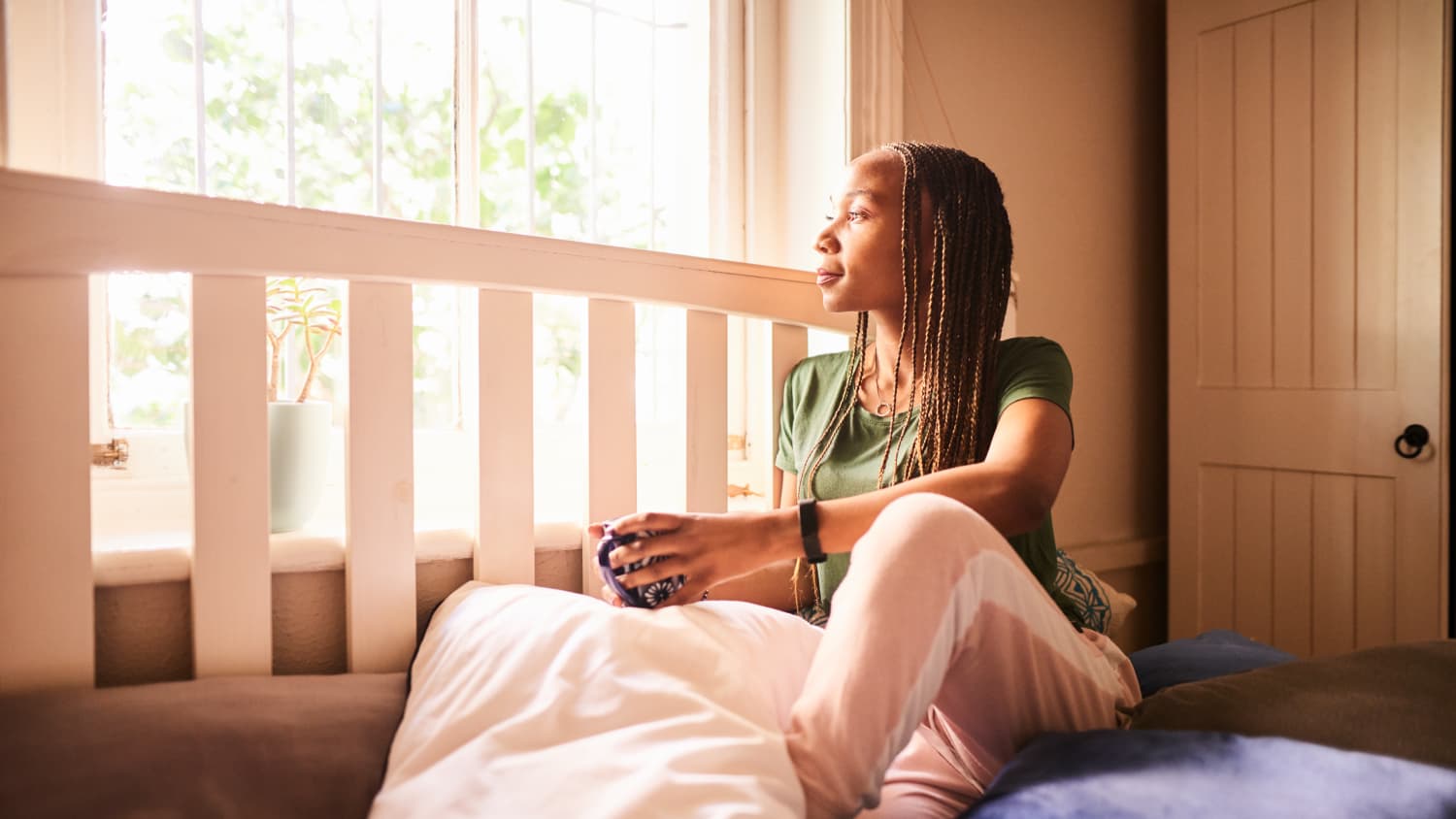 woman looking out her window, possibly after diagnosis of thyroid disease