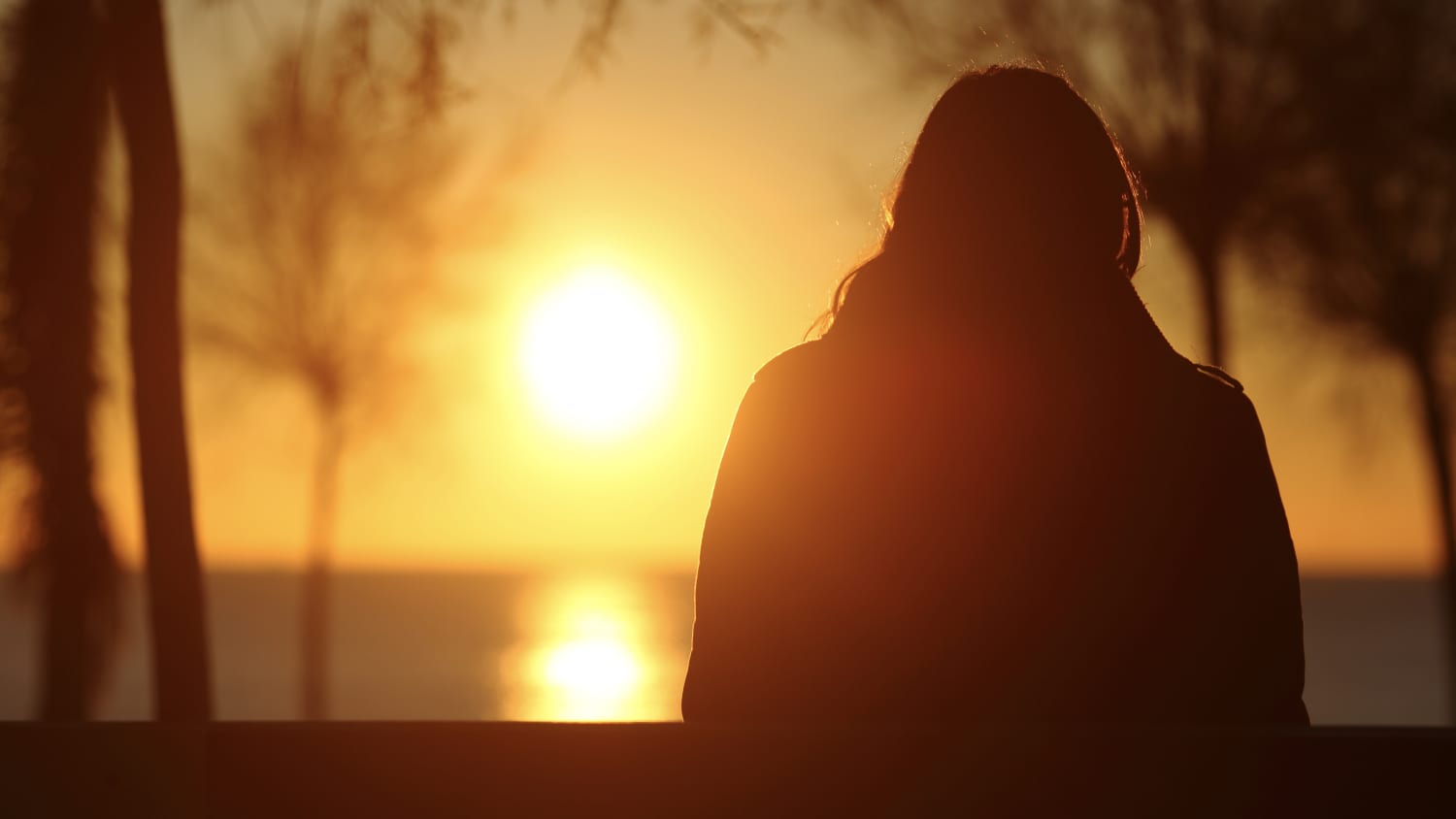 woman with seasonal affective disorder (SAD) looking at the sun, as possible light therapy