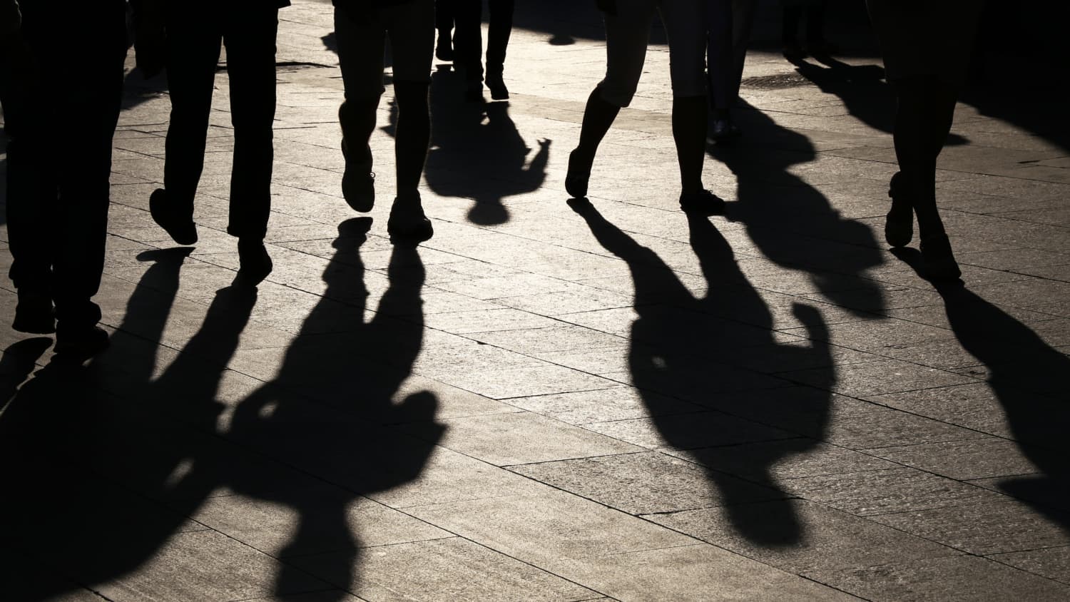 Shadows of people walking in streets, symbolizing the silent threat hepatitis C poses to millennials and baby boomers