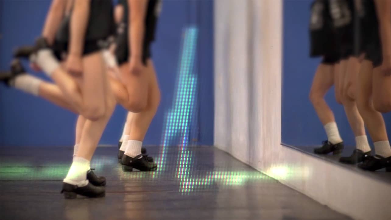 Irish step dancers dance while a heart monitor appears over them.