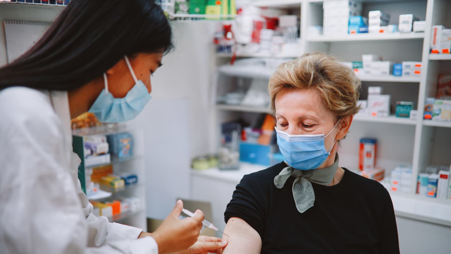 nurse giving a vaccine to an elderly patient