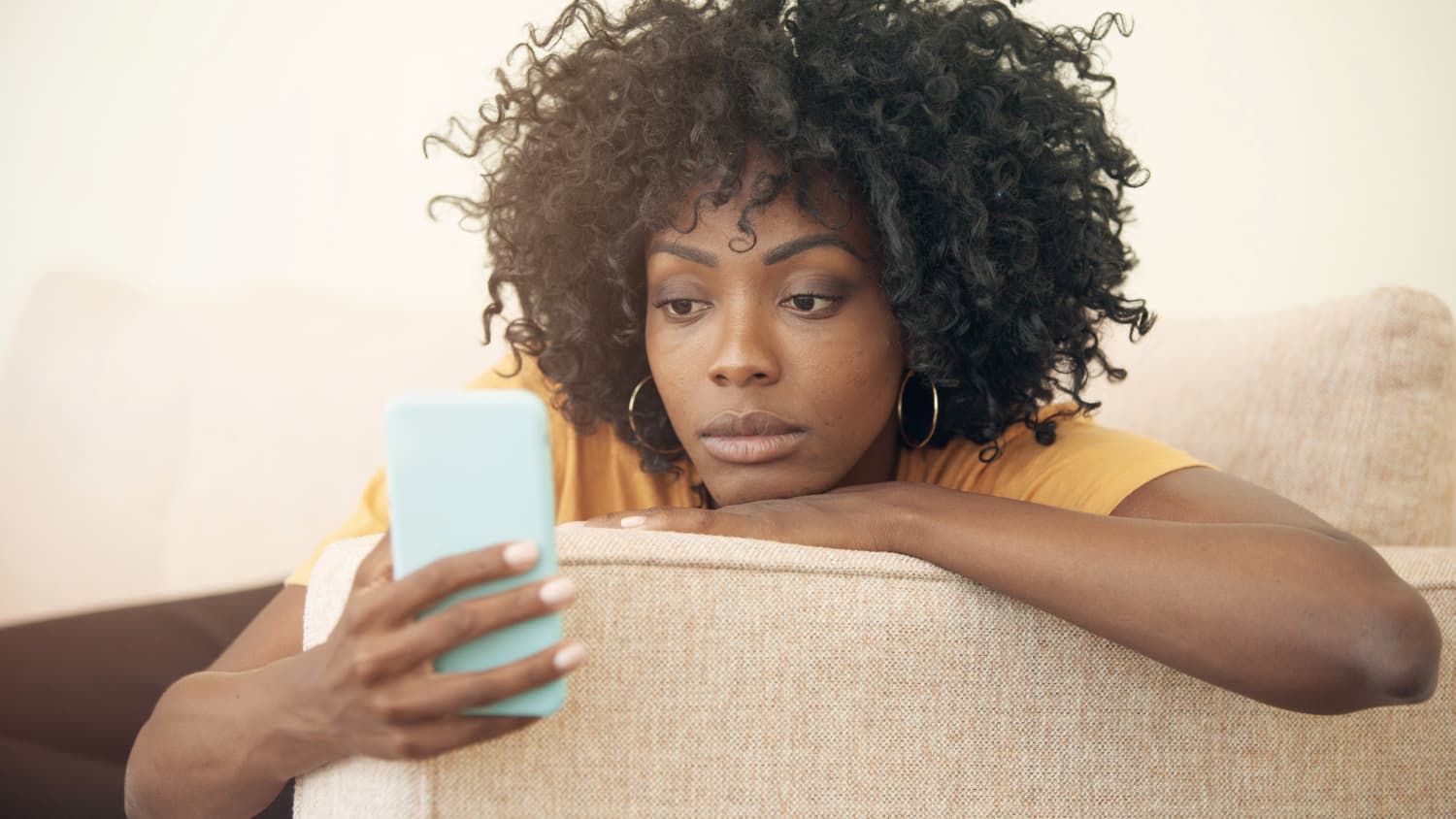 Woman looking at news updates on her phone, possibly to see connection between covid-19 vaccine and blood clots