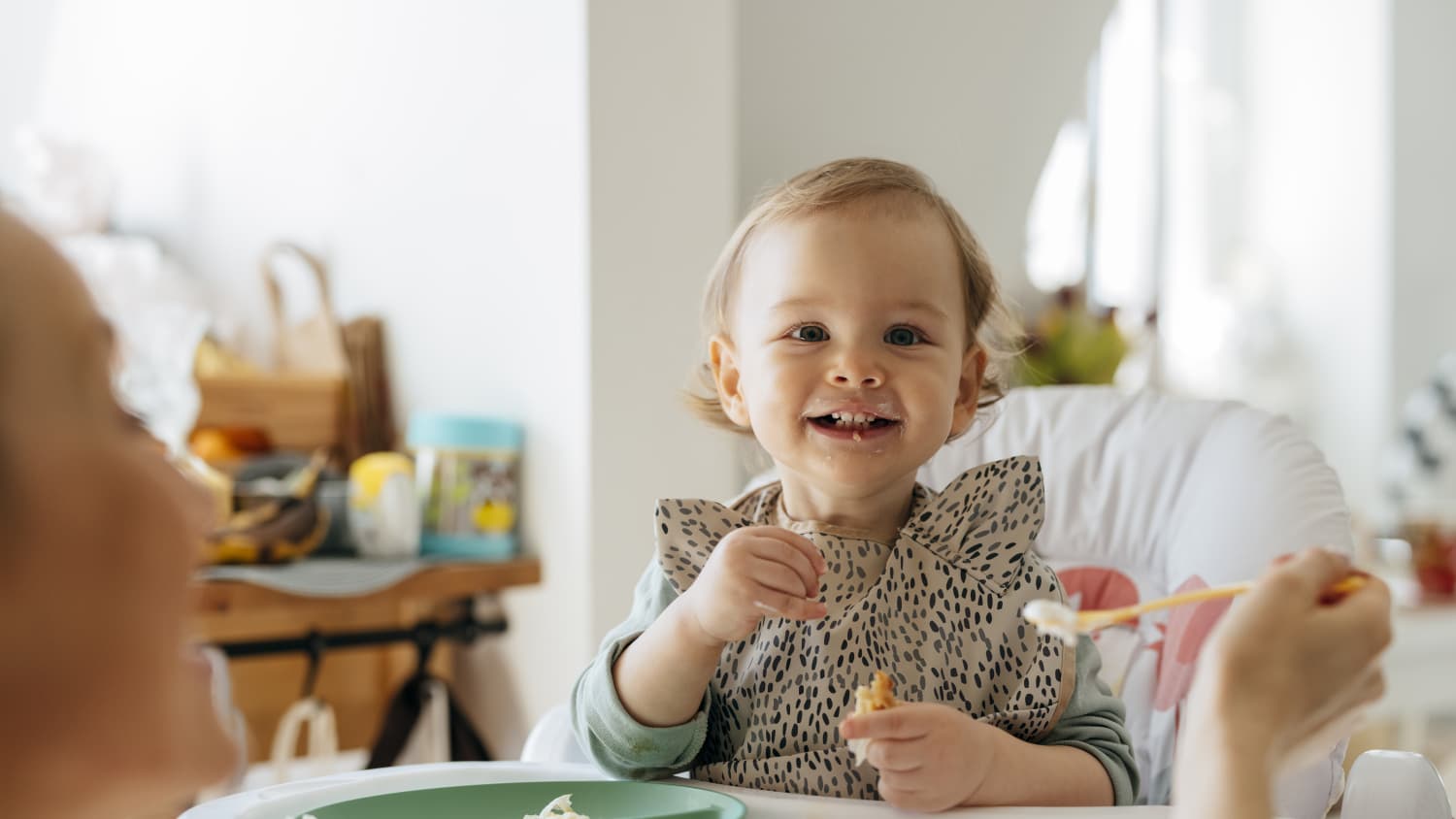 mother feeding her baby, attempting to avoid food allergies