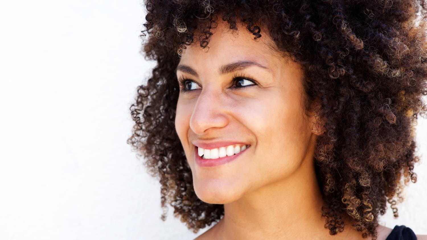 A young woman who may need anesthesia for fibroid surgery smiles.