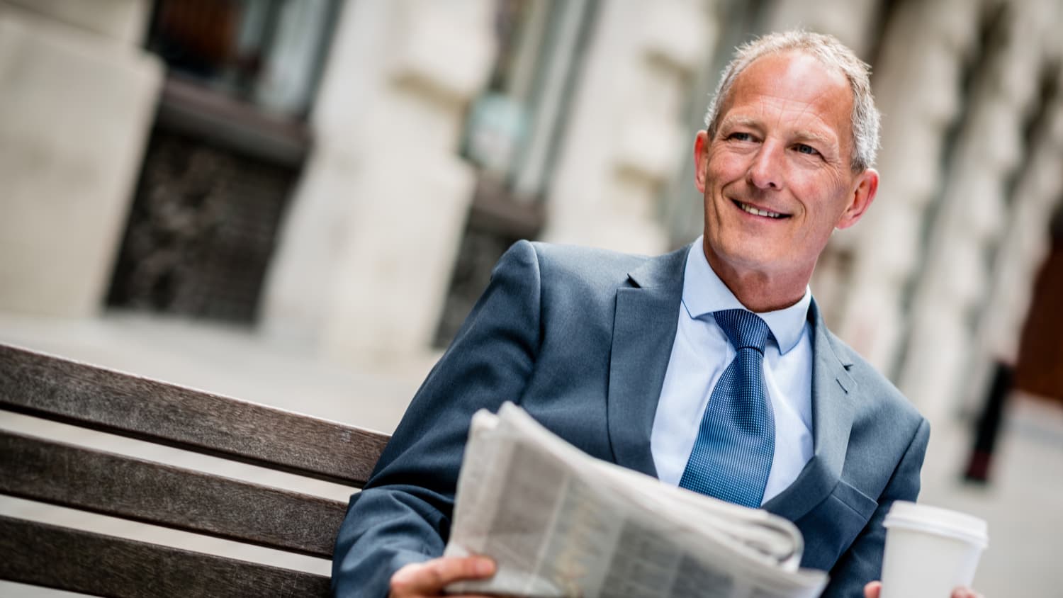 man sitting on a bench worried about the connection between smoking and cancer