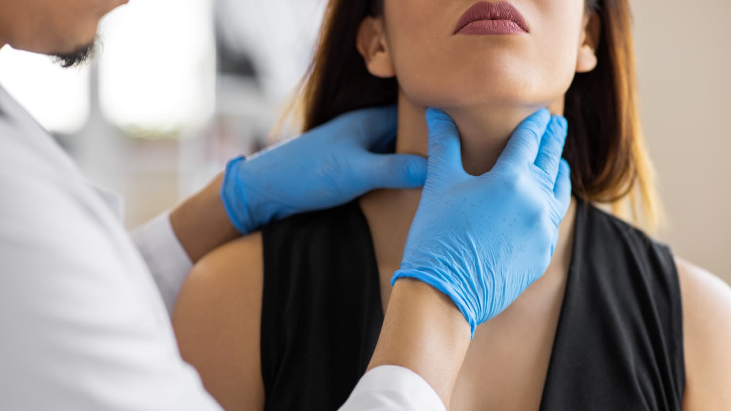 a doctor checks for thryoid nodules