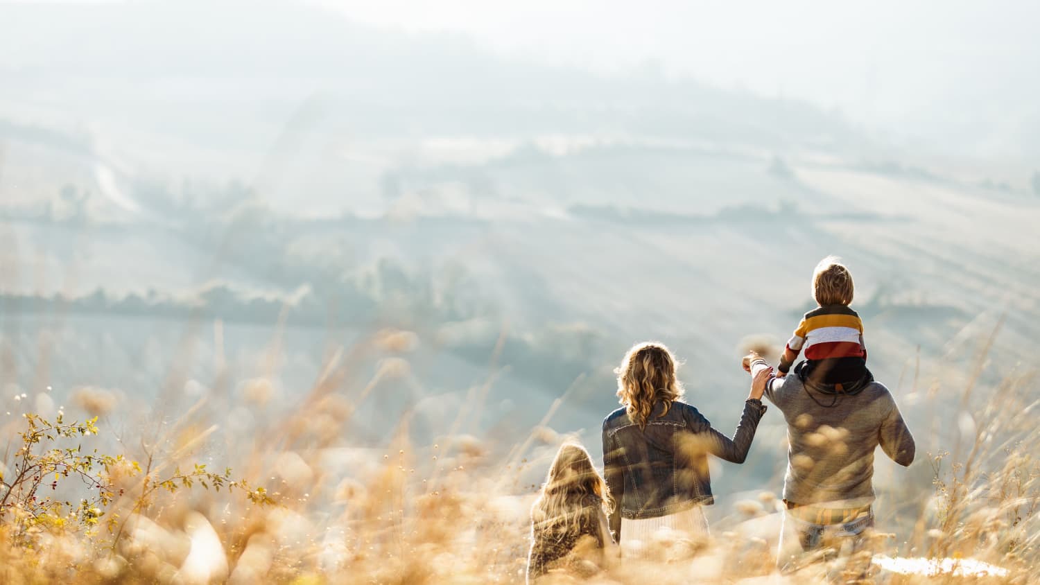 Rear view of a family standing on a hill in autumn day, symbolizing hope for the end of the COVID-19 pandemic