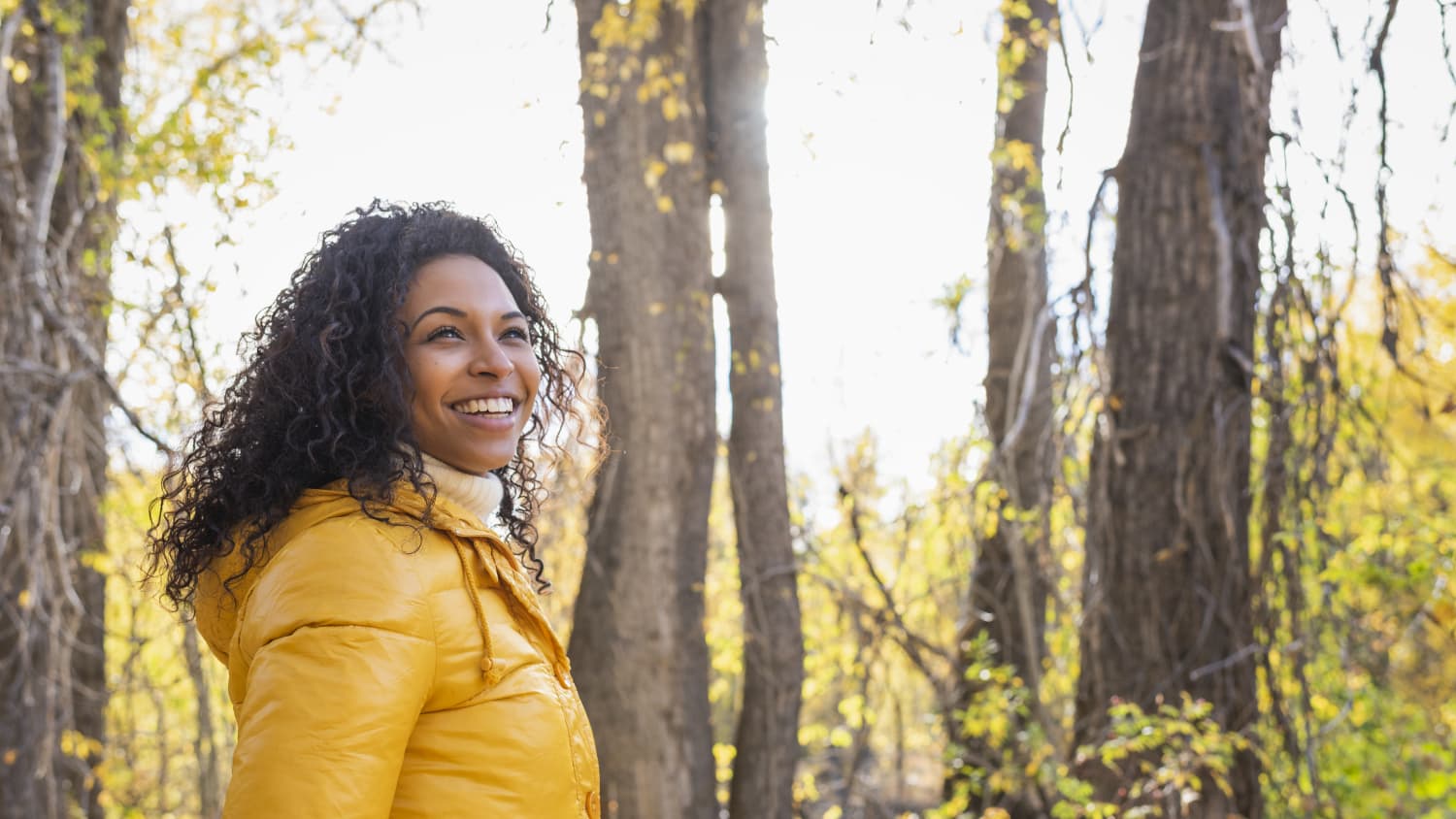 woman happy and walking in woods after transcranial magnetic stimulation (TMS) treatment