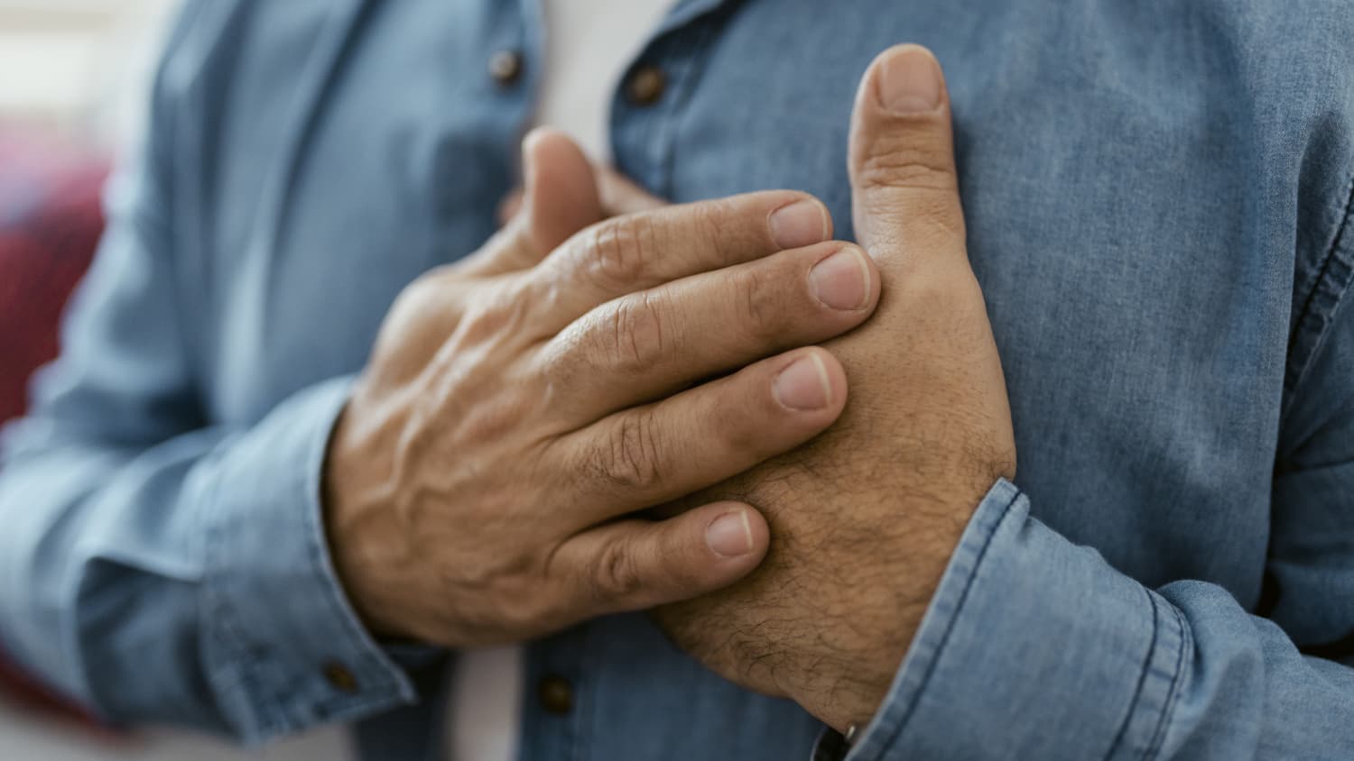 man with hands on chest.