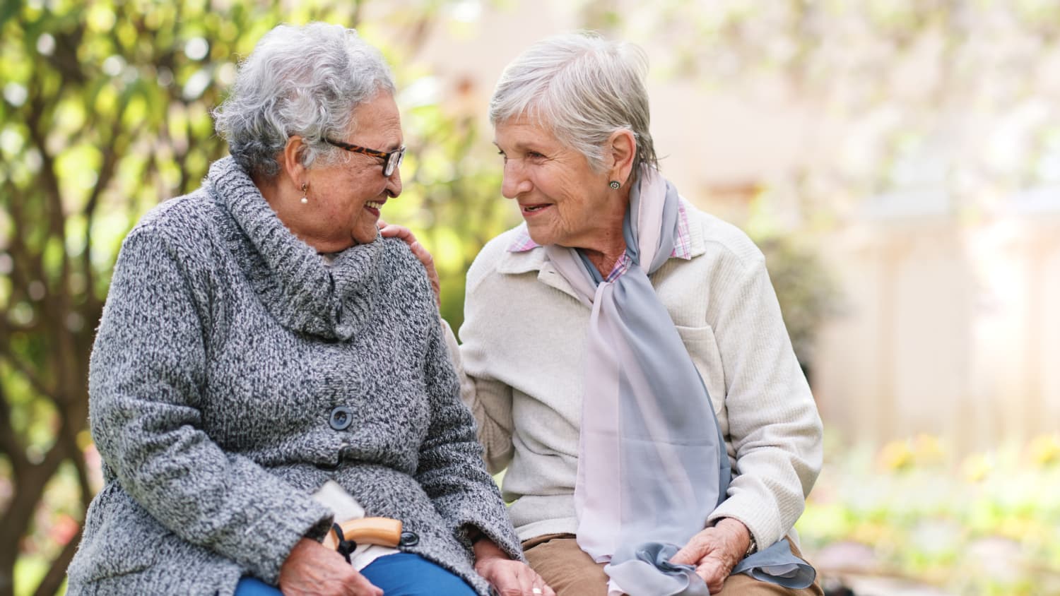 Two women sit together chatting. Socialization is one tool for preventing dementia.