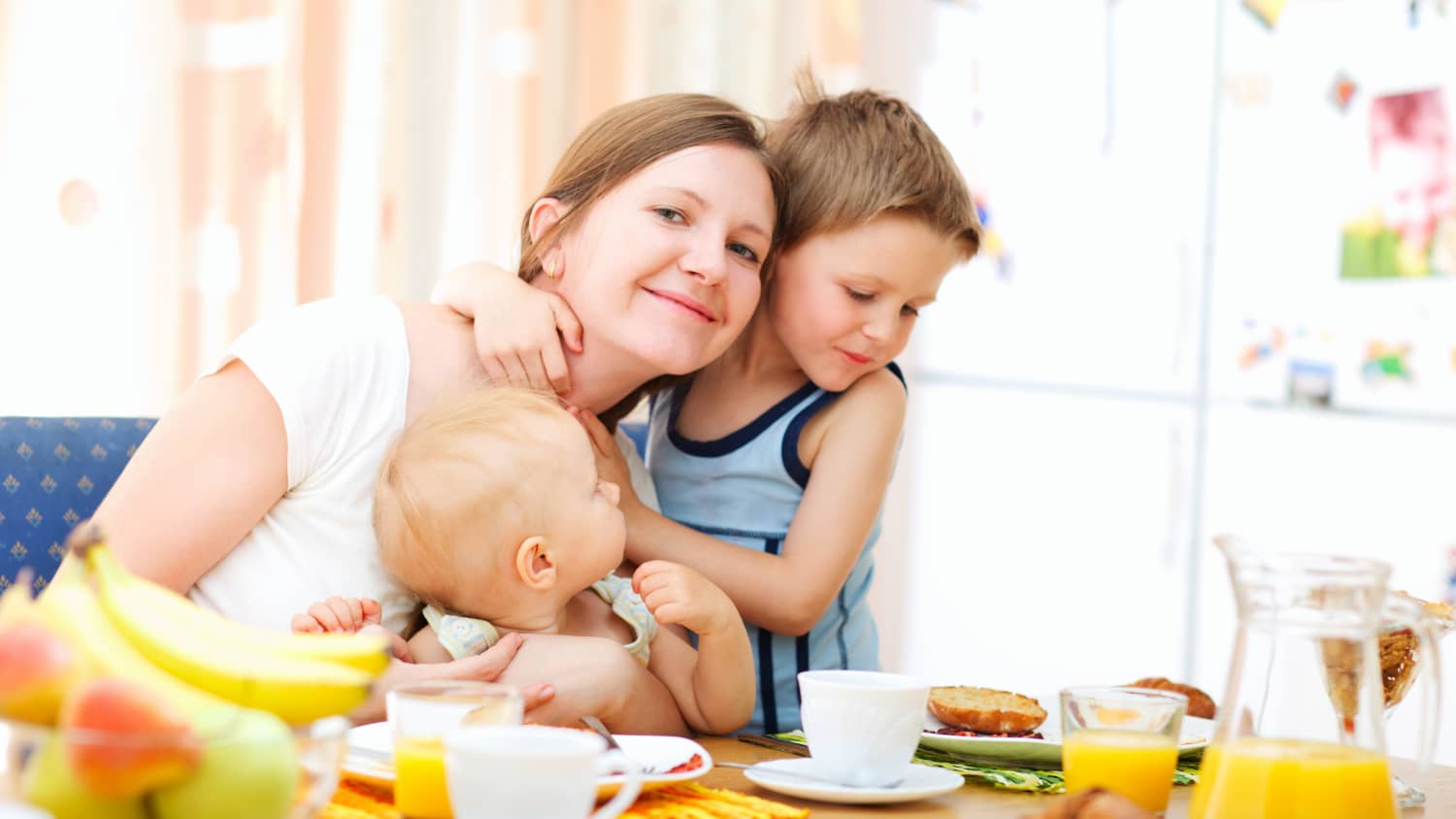 A mother with two young children at the breakfast table.