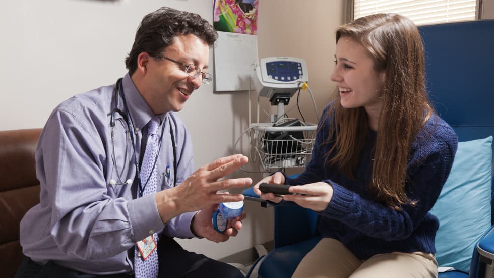 Dr. Stuart Weinzimer explains the new device for managing juvenile diabetes to a young patient.