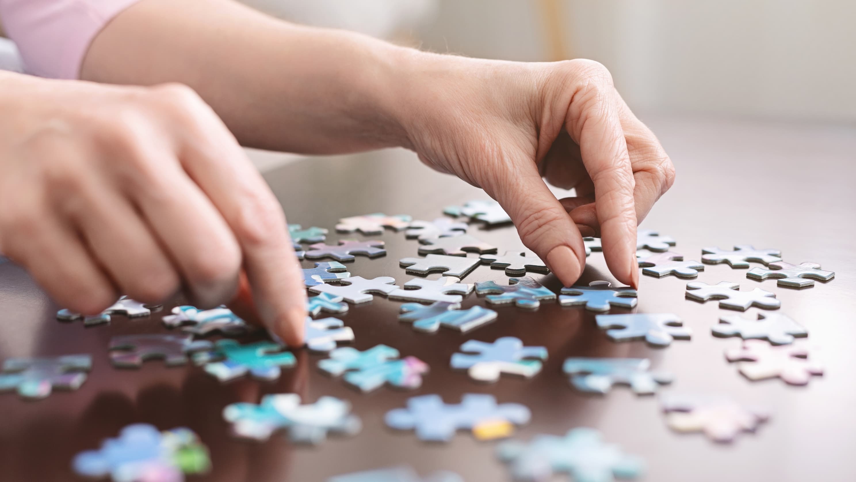 elderly person putting together a jigsaw puzzle, representing the confusion of dementia