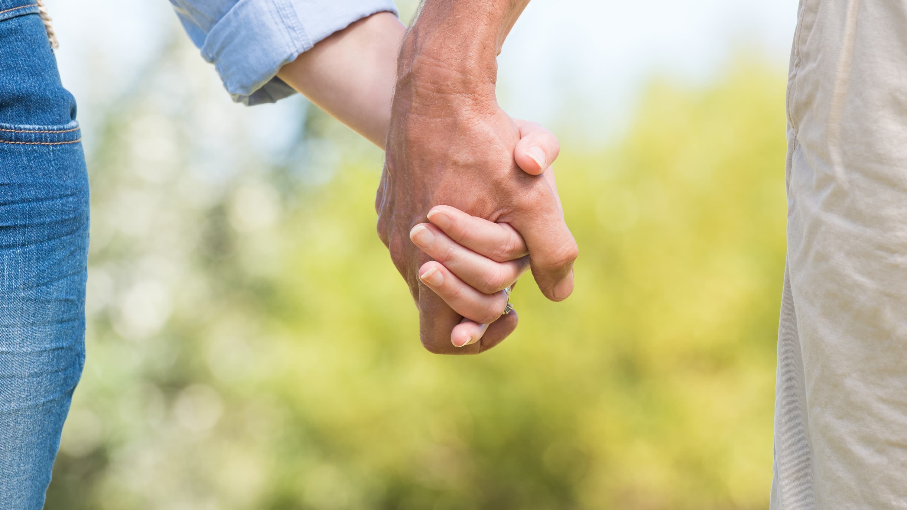 A close up image of two people holding hands, just the hands, in hopes of avoiding a sexually transmitted infection.