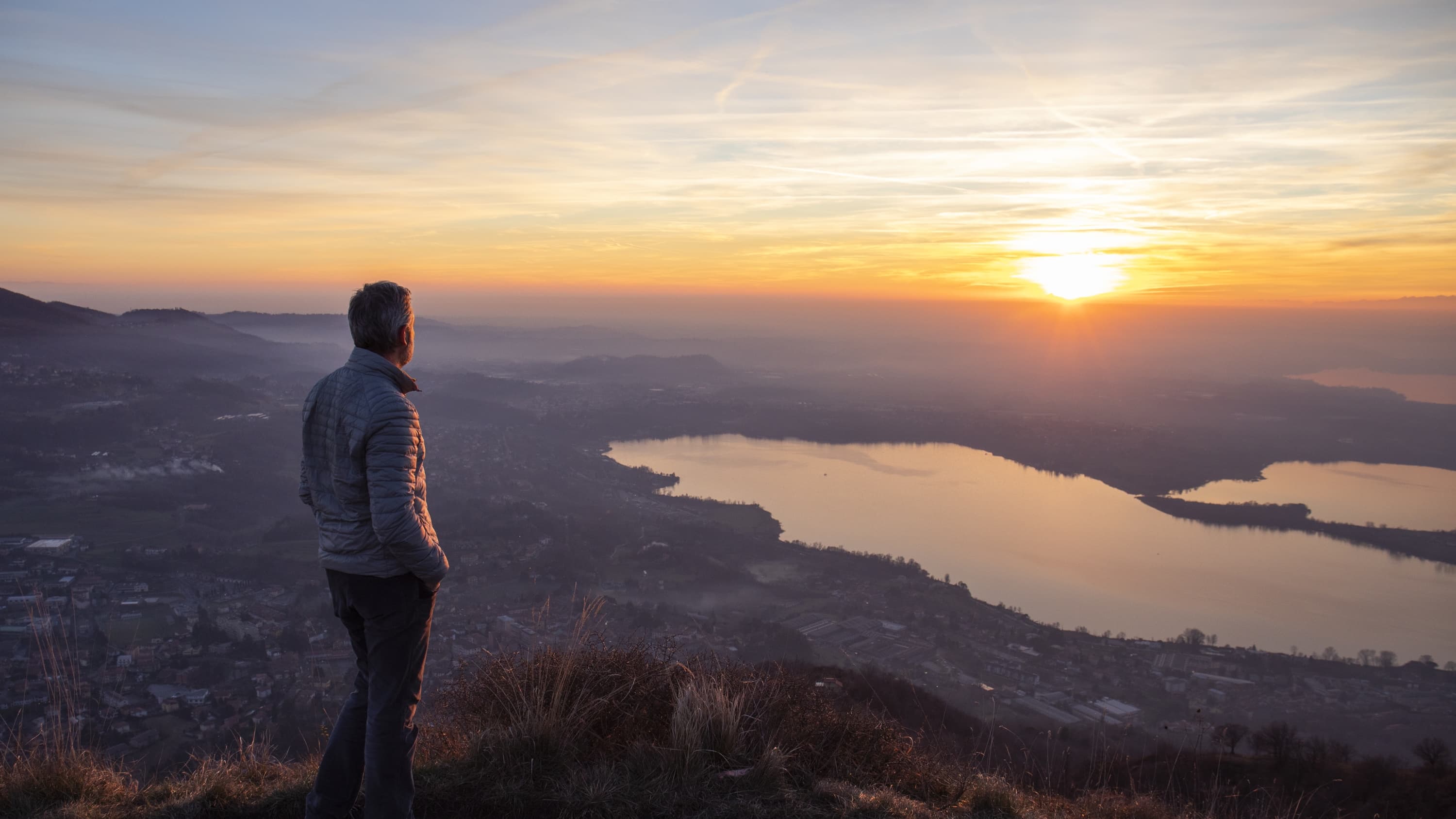 Hiker looking sun over horizon, possibly worried about neoplasm